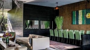 A modern living room with a sofa, chairs, a coffee table, and a fireplace. - Villa Mana | 7BR Tropical Estate Near Canggu Beach w/ Chef (Badung)