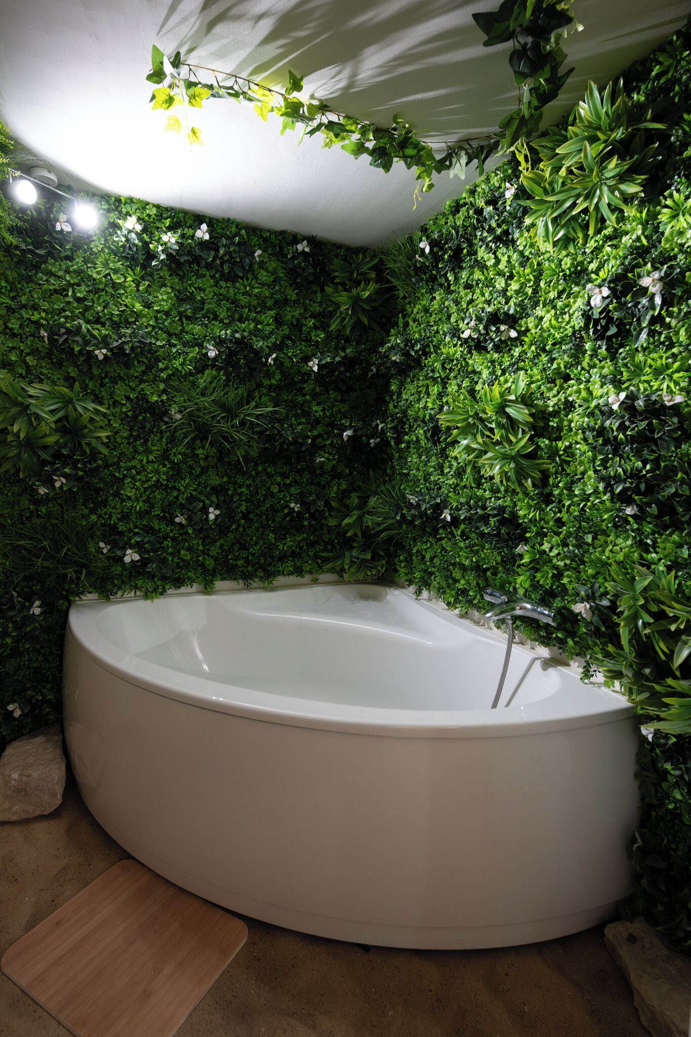 A spa area with a large white bathtub surrounded by lush green foliage.
