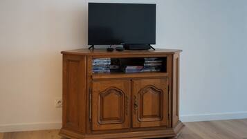 Eine Holzunterhaltungseinrichtung mit einem Flachbildfernseher, DVD-Player und verschiedenen Videospielen.