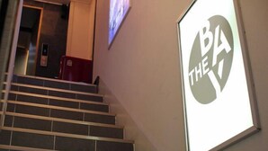 Un escalier avec une pancarte sur le mur où l’on peut lire : « BA THE ».