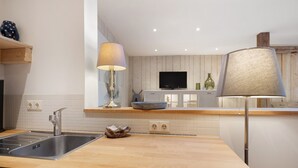 A modern kitchen with a wooden countertop, stainless steel sink, and a television mounted on the wall. - Apartment 'Nahe Blauen Wunder' with Shared Terrace, Shared Garden and Wi-Fi (Dresden)
