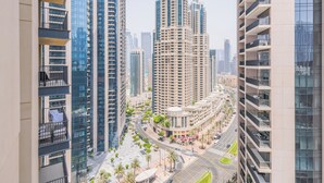 A high-rise building with multiple balconies and a curved structure in the background. - BLVD Heights Residences - Downtown (Dubai)