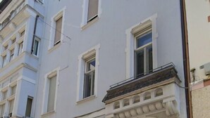 A multi-story building with a classic architectural style, featuring a central entrance with a wooden door and decorative elements. - Talvera Dream (Bolzano)