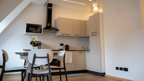 A modern kitchen with a dining area, featuring a microwave, stove, and a hanging light fixture. - Talvera Dream (Bolzano)