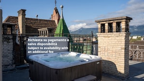 A hot tub on a rooftop with a view of mountains and traditional architecture in the background. - Talvera Dream (Bolzano)