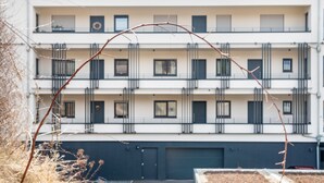 A multi-story building with balconies, a garage, and a clear sky. - Apartment 'Bei Stefanie' with Mountain View, Balcony and Wi-Fi (Bad Kötzting)