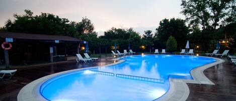 A swimming pool with lounge chairs and a lifebuoy.