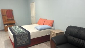 A bedroom with a bed, a black leather chair, a wooden dresser, and a wardrobe. - Serene Apartment Near UN, Banks, and Airport in Honiara (Honiara)