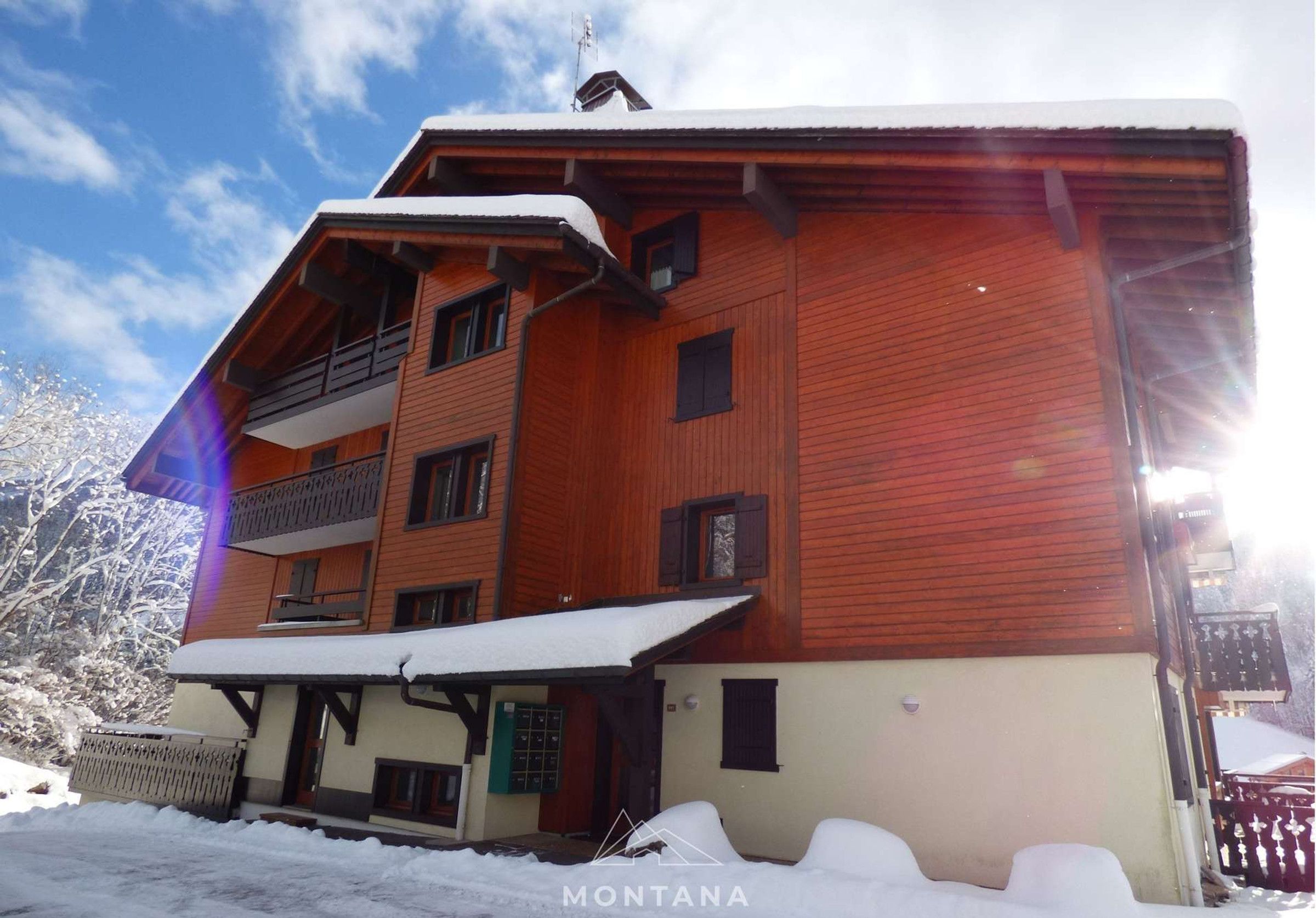A multi-story wooden building with balconies, surrounded by snow.