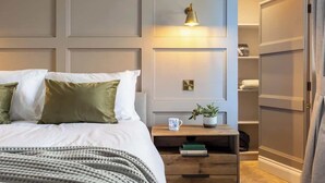 A neatly arranged bedroom with a bed, bedside table, and a wardrobe.