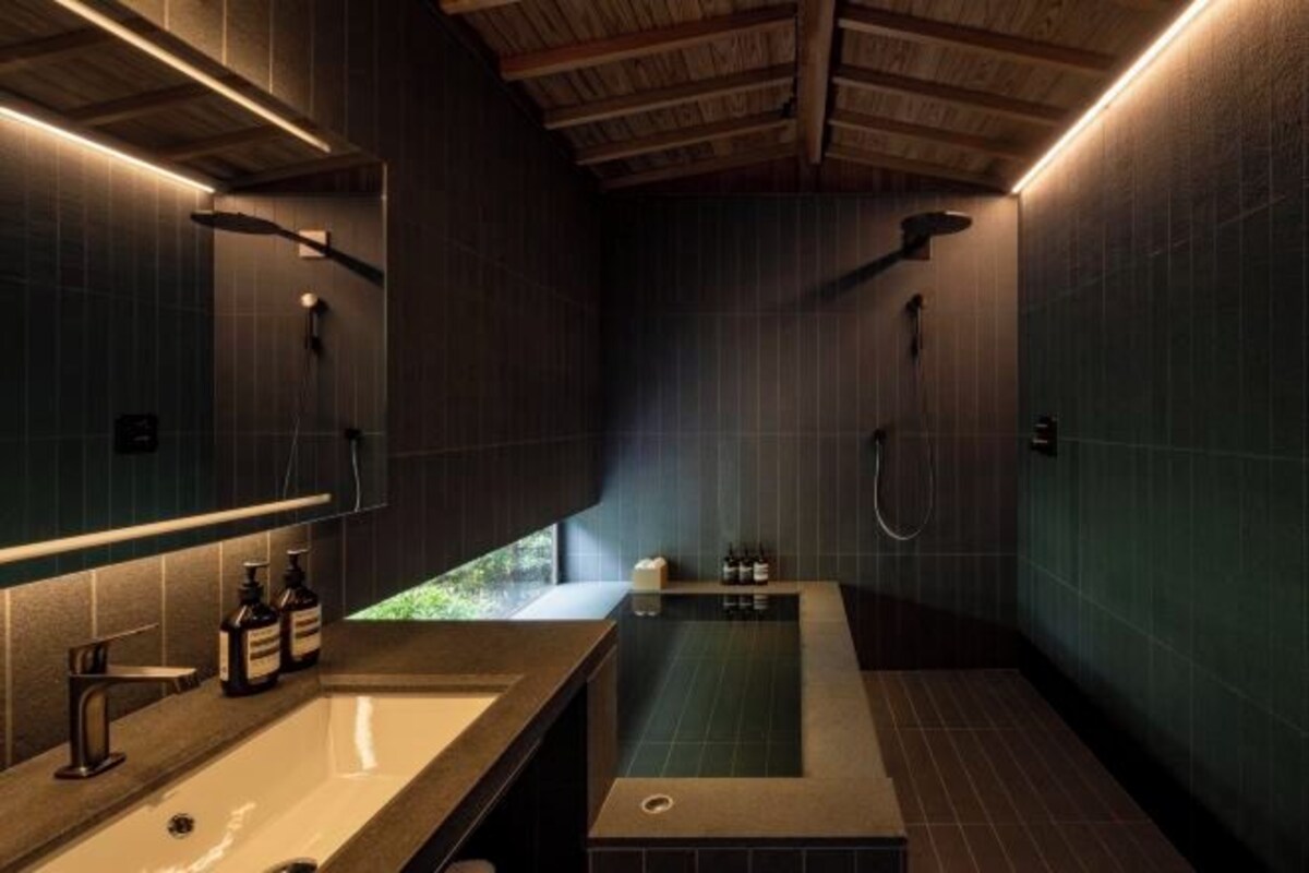 Un baño moderno con una bañera grande, un lavabo y un espejo.