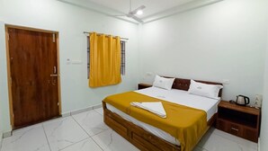 Un dormitorio con cama de madera, paredes blancas, ventilador de techo y ventana con cortinas amarillas.