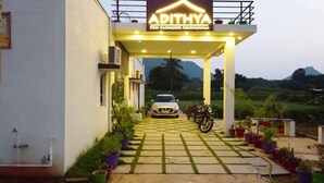 Entrada de un hotel con un cartel que dice "APITHYA STAY ALONGSIDE ARUNACHALA".