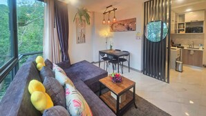 Una sala moderna con un sofá, una mesa de comedor y una zona de cocina.