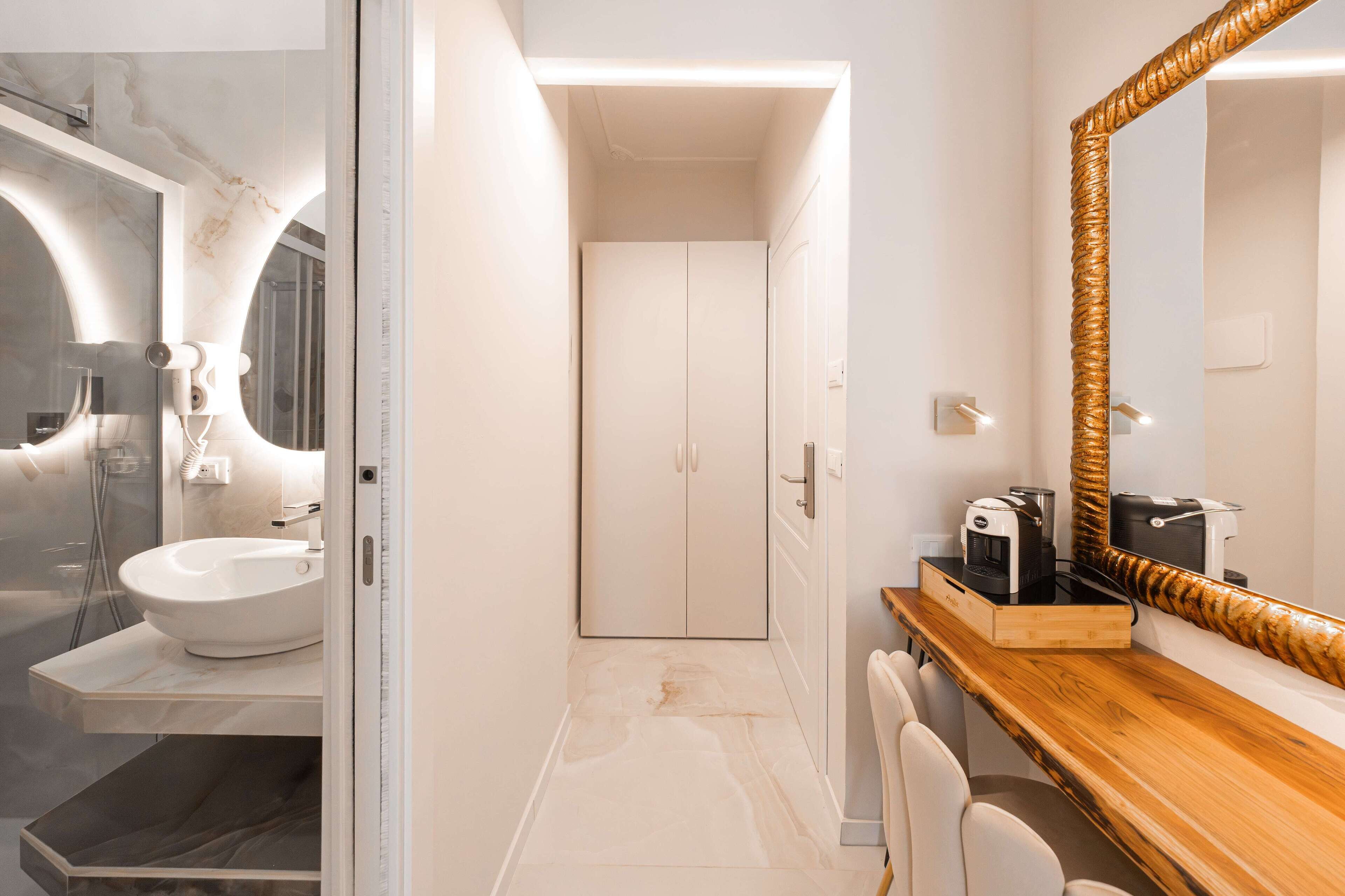 A modern bathroom with a white sink, a glass shower enclosure, and a wooden vanity with a large mirror.