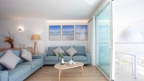 A modern living room with a sofa, coffee table, and artwork on the wall.