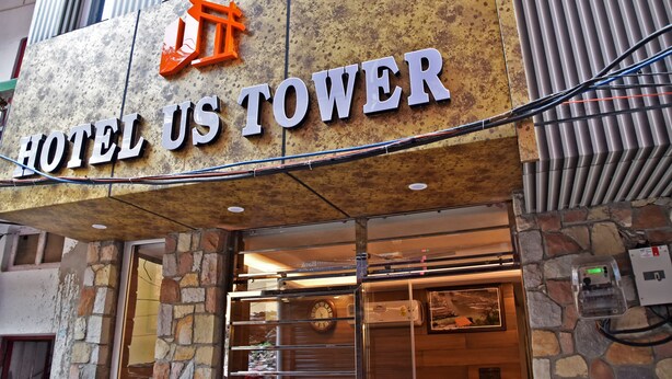 A hotel entrance with a stone facade and a sign reading "HOTEL US TOWER". - Hotel US Tower (Devaprayāg)