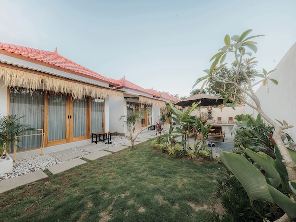 A courtyard with a traditional tiled roof, wooden doors, and a small table. - Hiraya Uluwatu (Pecatu)