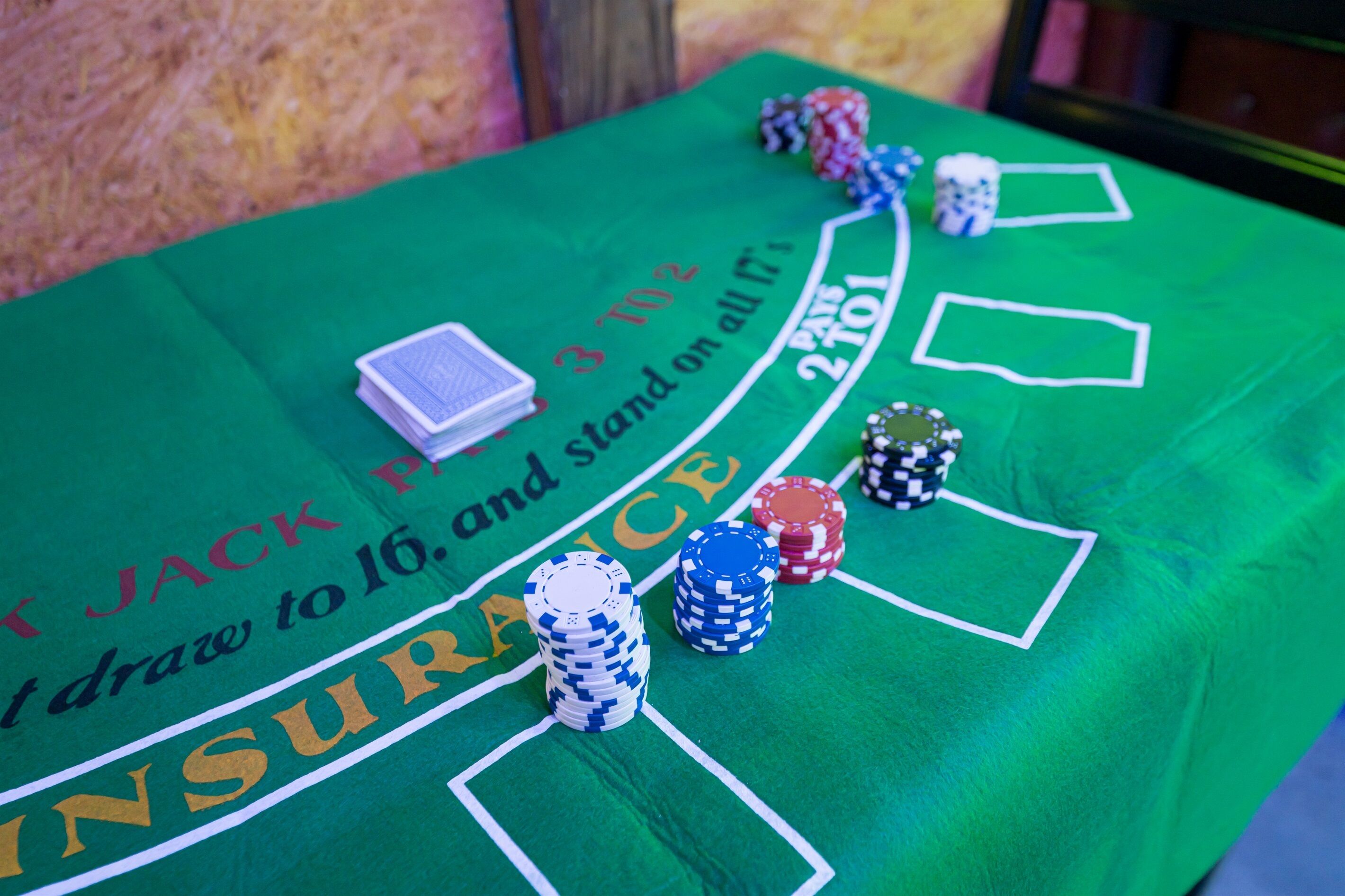 A green table with poker chips and playing cards, indicating a casino setting.
