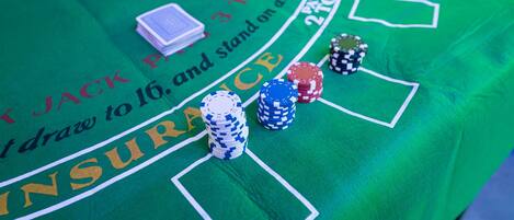 A green table with poker chips and playing cards, indicating a casino setting.