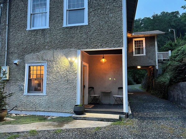 A house with a gravel driveway, a front porch with two chairs and a table, and a small garden area. - Marshall House Inn Grandview Suite, Walk Downtown (Marshall)