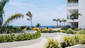 Ein Resort mit Poolbereich, Palmen und Meerblick.