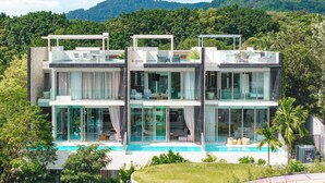 A modern two-story house with a swimming pool, large windows, and a view of a forested mountain. - Sea Theatre Kata by ROI (Karon)