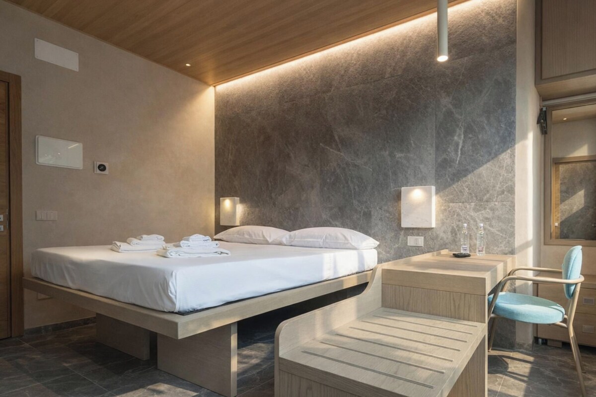 Une chambre à coucher moderne avec un lit, une table de chevet, une chaise et un banc.