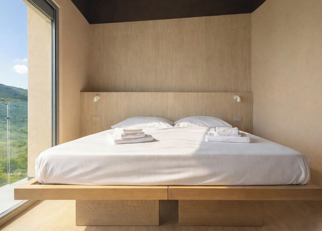 Una camera da letto moderna con un letto, cuscini e asciugamani.
