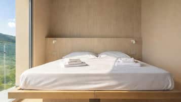 A modern bedroom with a bed, pillows, and towels.