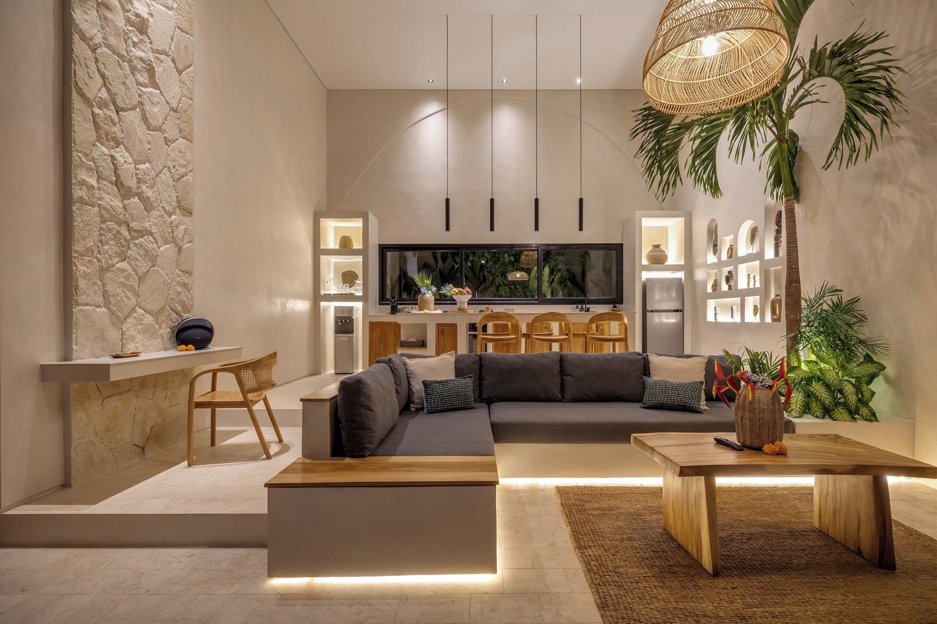 Una sala de estar moderna con un sofá modular, una mesa de centro de madera y un televisor al fondo.