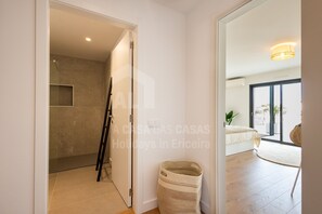 A modern hotel room with a shower, a bed, and a view of the outdoors. - Casa Brisa by Acasadascasas (Mafra)