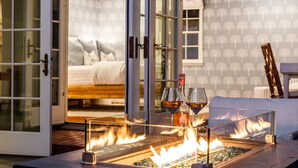 A room with a glass table set for two, a bed with pillows, and a view through a glass door. - Coastal Elegance by the Shore (La Jolla)