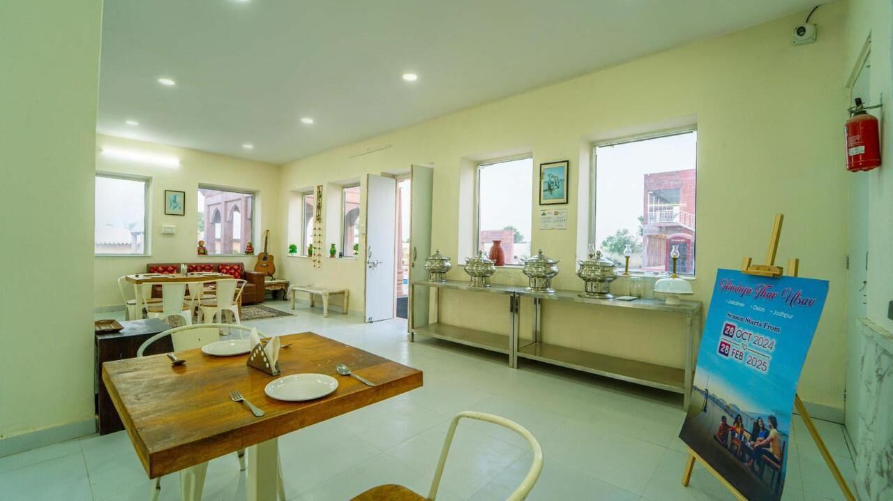 Un comedor con una mesa de madera dispuesta para cuatro personas, un banco con cojines y un ventanal con vistas.