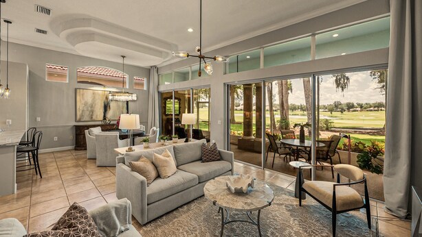 A spacious living room with a large window, a dining area, and a kitchen.