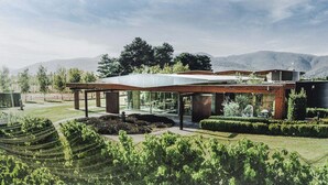 Un bâtiment moderne doté d’un toit plat, de grandes fenêtres en verre et d’un espace extérieur abrité.