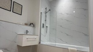 A modern bathroom with a glass-enclosed shower, a white vanity, and a wooden floor. - Premium apartment close to the beach, Turner contemporary and dreamland Pets ok. (Margate)