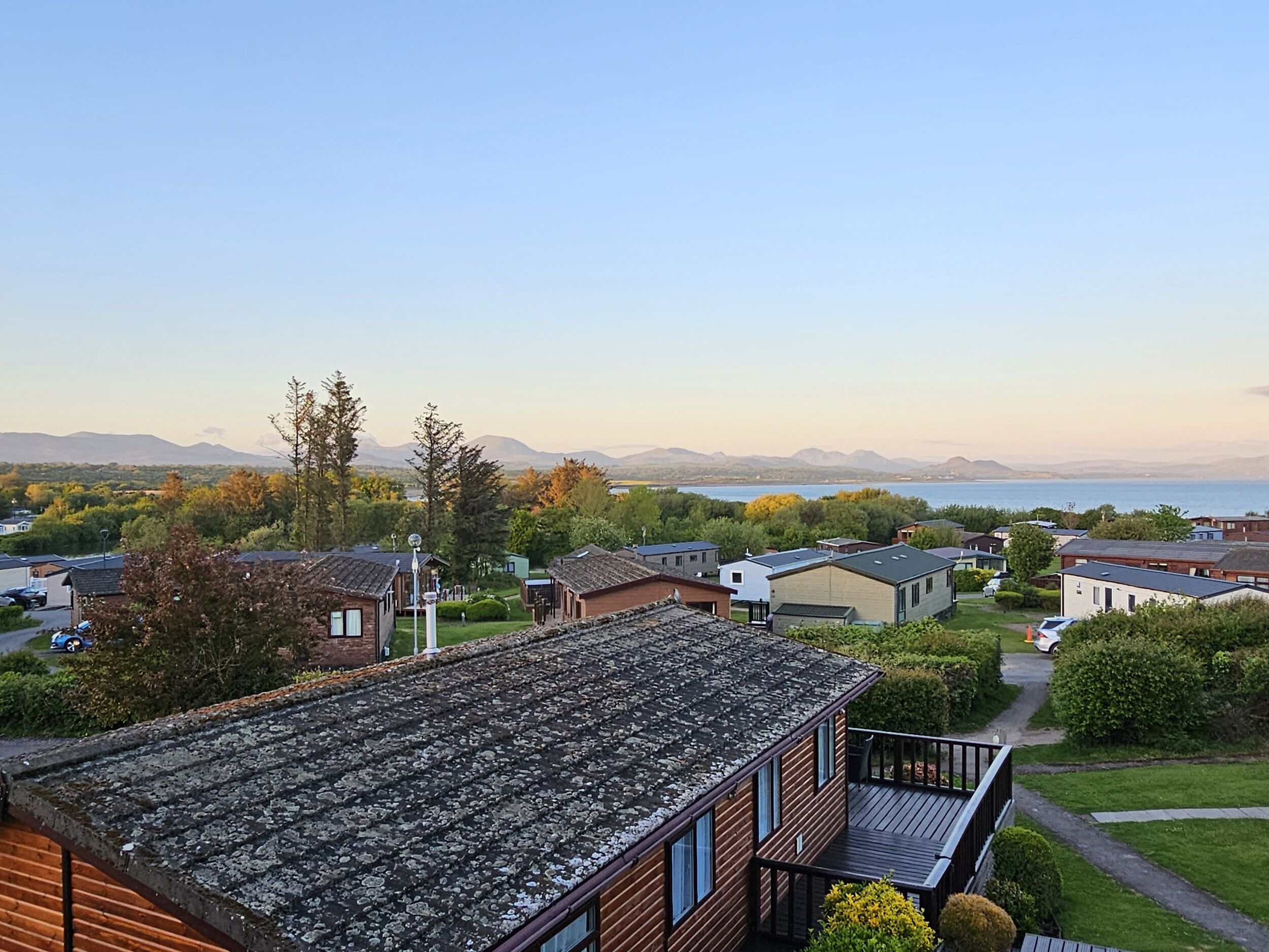 Et boligområde med huse, en klar himmel og et fjerntliggende vandareal.