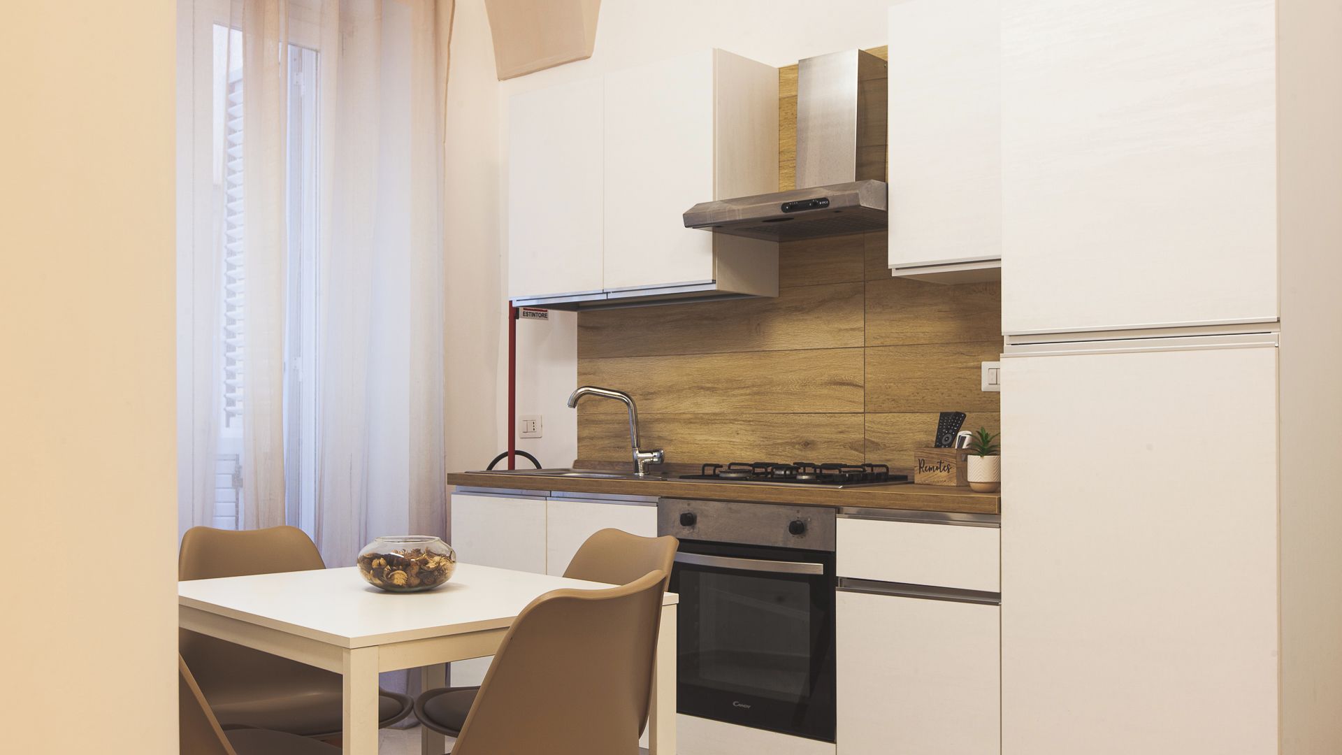 Una cocina compacta con estufa, horno y una mesa de comedor con sillas.