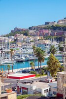 Una marina con numerose imbarcazioni ormeggiate, una stazione di servizio e sullo sfondo edifici storici.