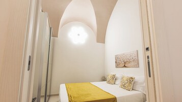 Una camera da letto con un letto, un quadro e una coperta gialla.