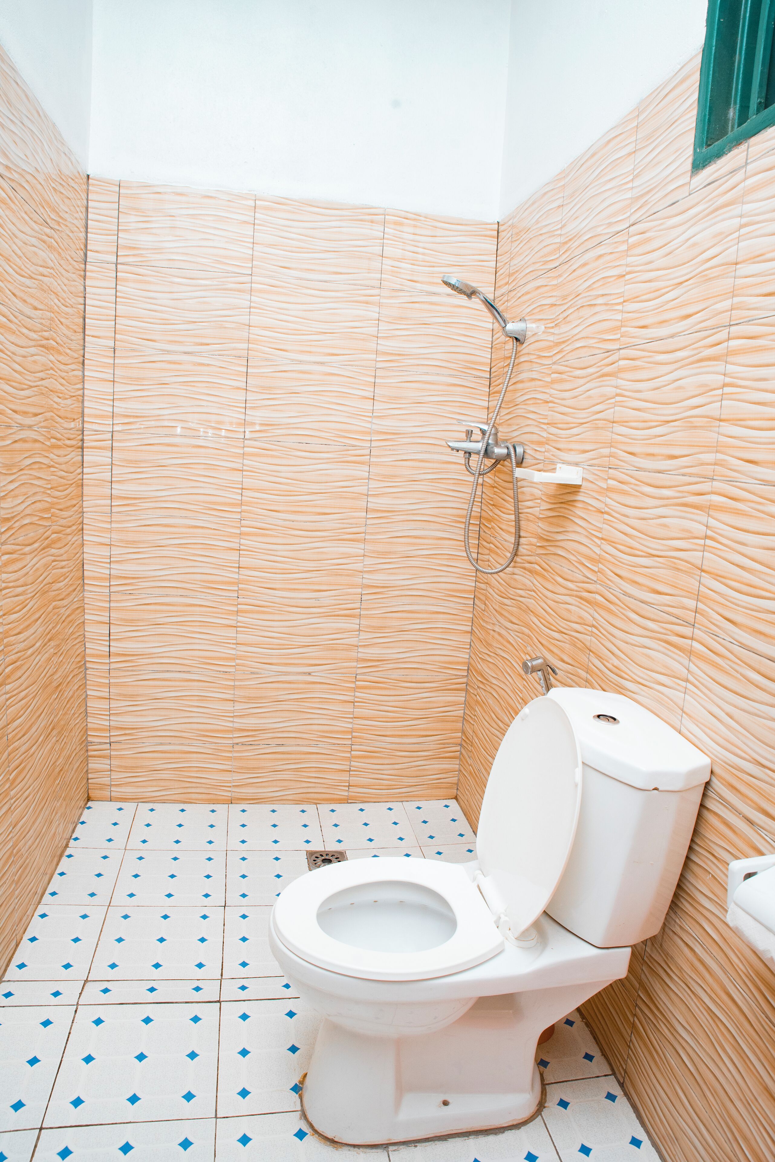 A bathroom with a toilet, shower, and tiled walls.
