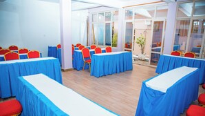 A conference room with tables and chairs, large windows, and a view of the outdoors. - Fanad Hotel (Gisenyi)
