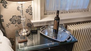 Ein Hotelzimmer mit einem Glastisch, auf dem eine Flasche, zwei Gläser und ein Tablett stehen.