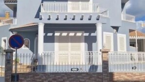 A large, light blue house with a balcony and a garage. - Dona Ana Guesthouse (Lagos)