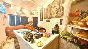 Un área de recepción con mostrador, asientos y una pared decorada con arte cultural.