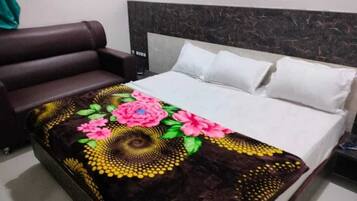 A bed with a floral bedspread, a dark headboard, and white pillows.