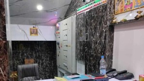 A reception desk with a marble wall, a security camera, and a signboard.