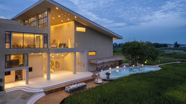Una moderna casa a due piani con una grande piscina esterna, un portico coperto e un prato curato.