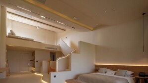 Una camera da letto moderna con un letto grande, una scala in legno e un design minimalista.
